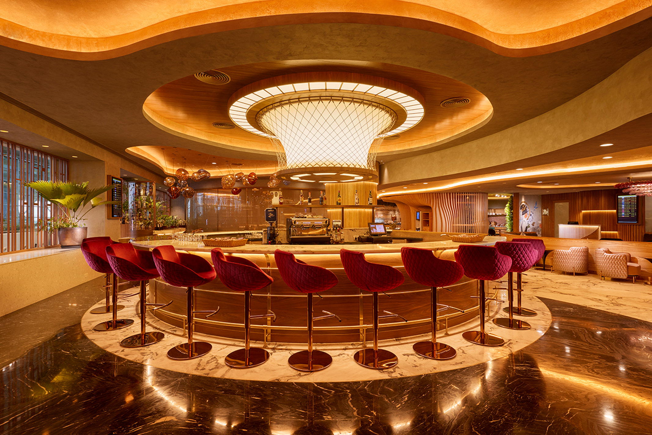 a bar with red high bar chairs in a room