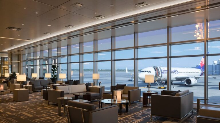Modern airport lounge with comfortable seating and tarmac view.