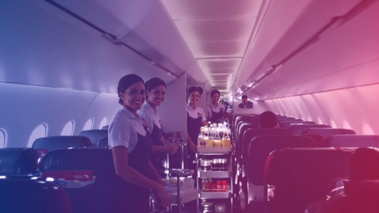 British Airways flight attendants with beverage carts in cabin.