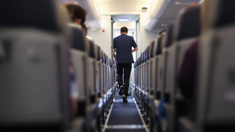Passenger quickly exiting airplane aisle.