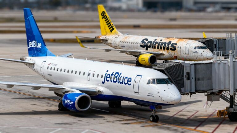 JetBlue and Spirit planes at airport gate.